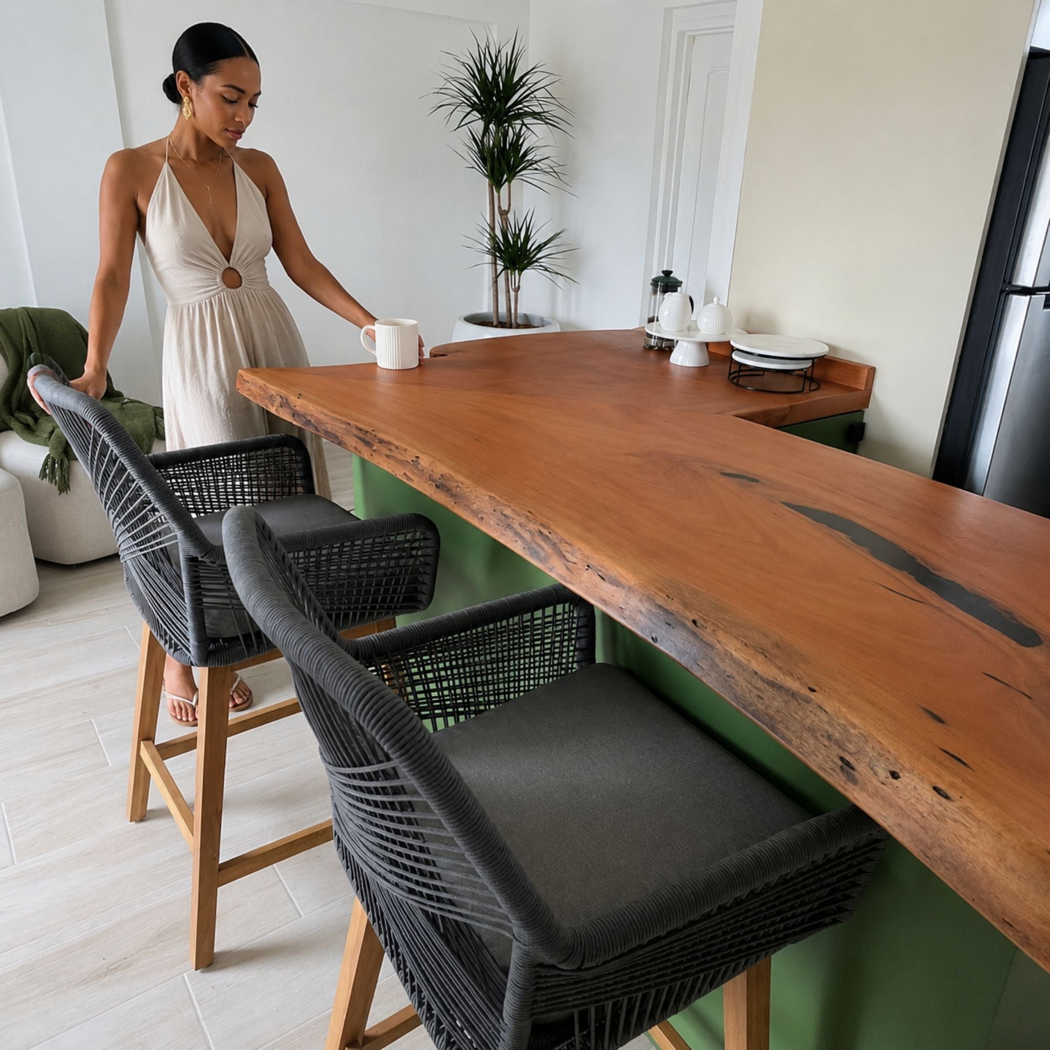 Bespoke live-edge mahogany kitchen counter shown in context with bar seating for scale.
