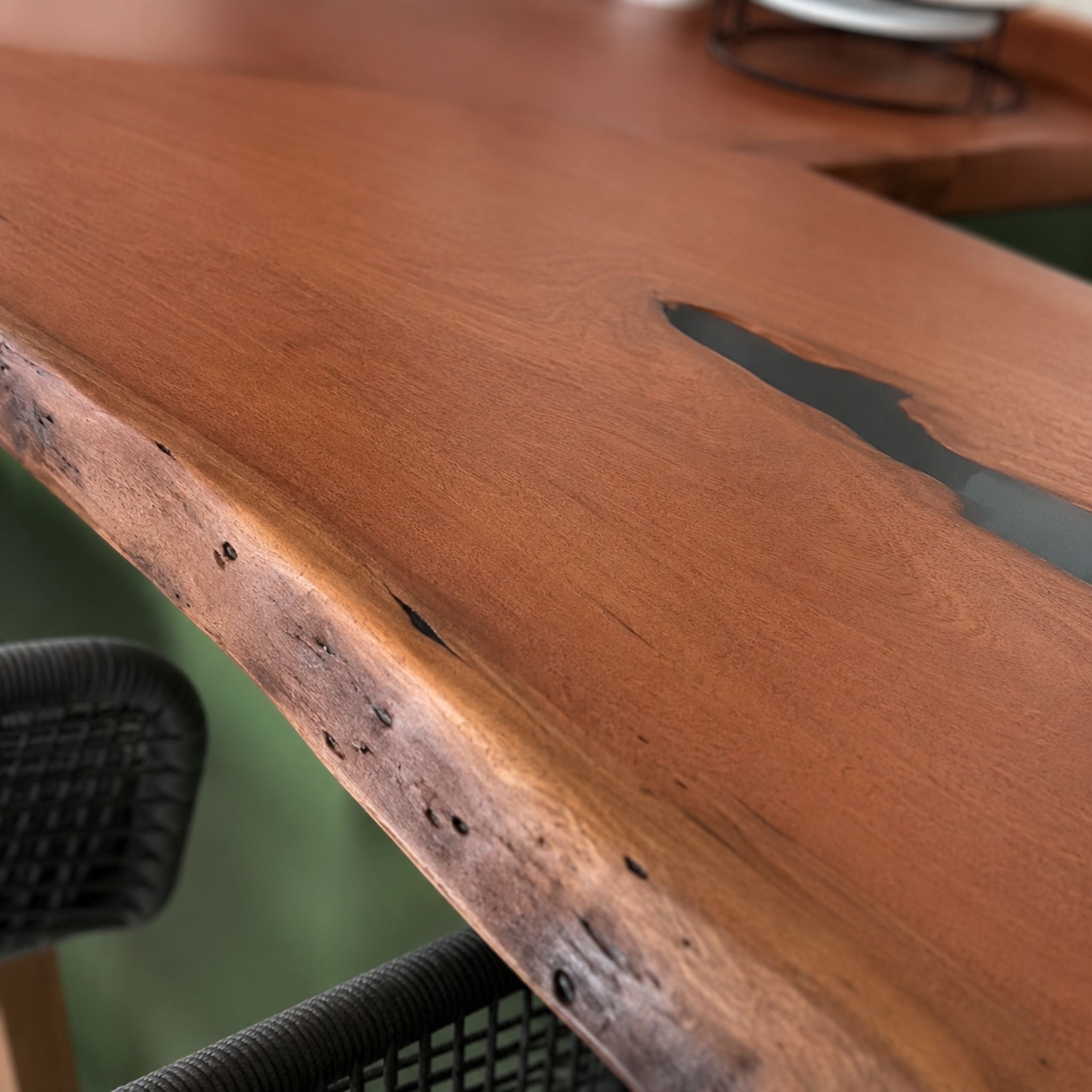 Close-up of natural mahogany grain and dark resin-filled voids on a bespoke kitchen counter.